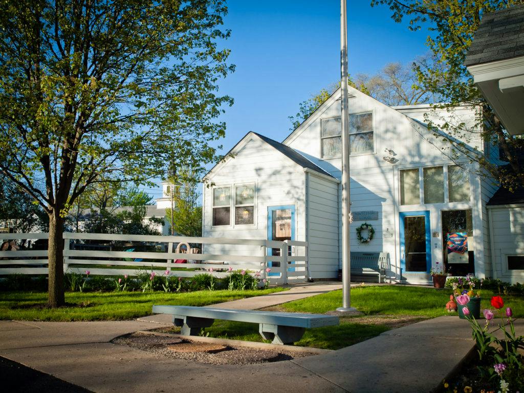 White house with blue trim and a flagpole in front