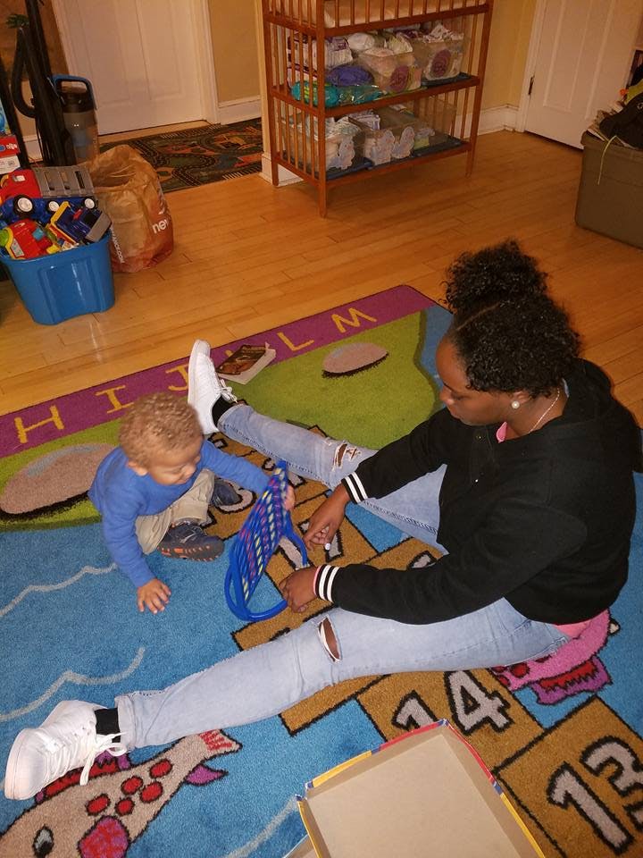 Person and child playing a game on a rug
