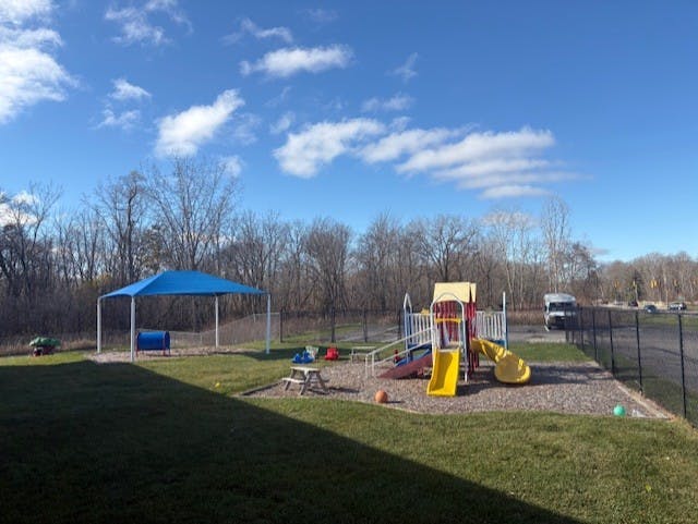 An outdoor playground with slides and a blue canopy