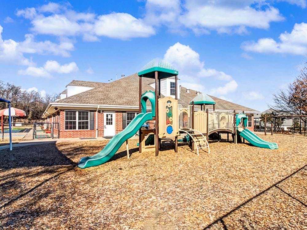 Playground with slides and climbing structures in front of a building