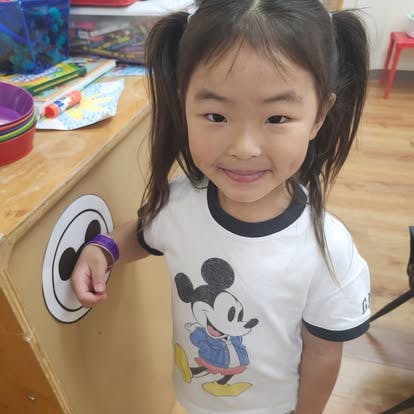 Child in pigtails wearing a Mickey Mouse shirt