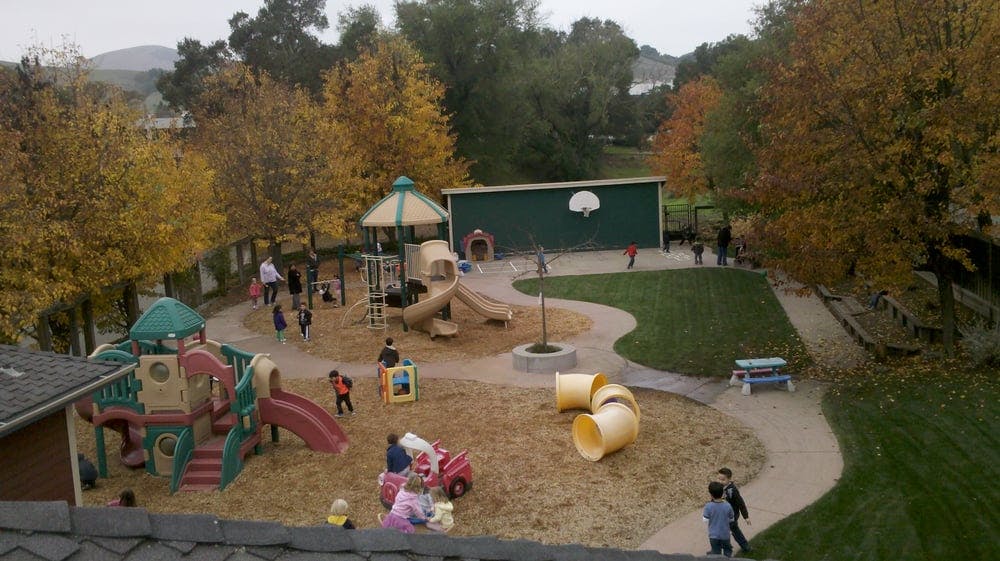 Children playing on a playground with slides and climbing structures