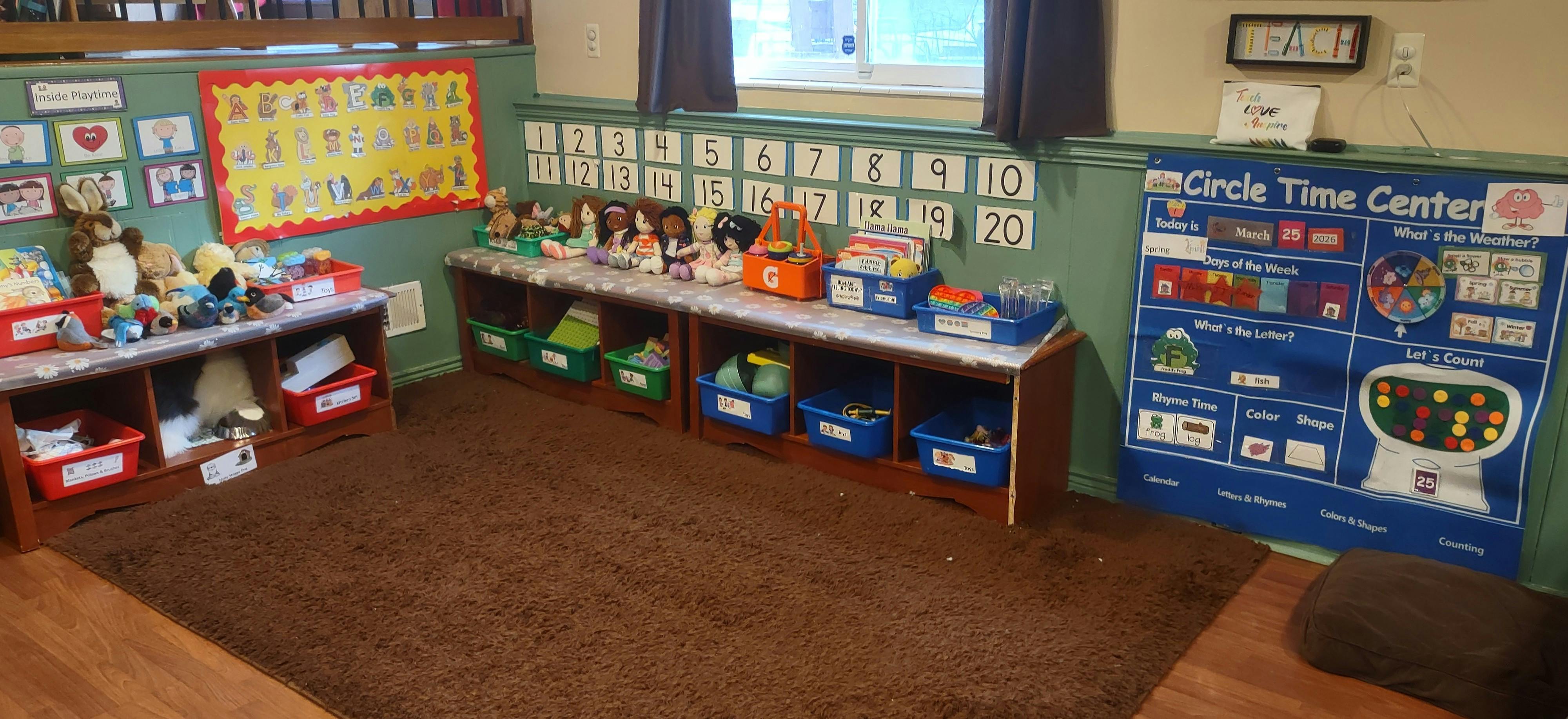 Classroom corner with toys, storage, alphabet and number charts, and circle time center
