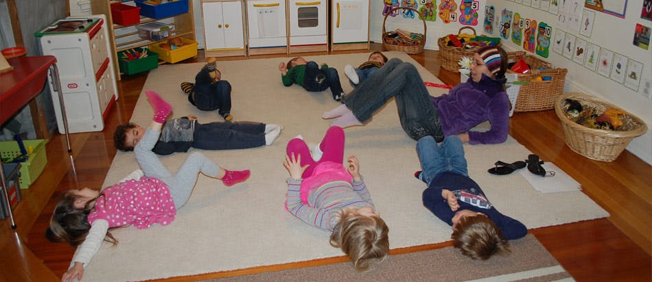 Children lying on a rug in a classroom