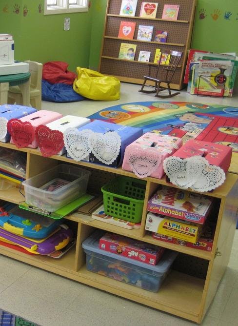 Classroom with a bookshelf, beanbags, and a low shelf with toys and boxes