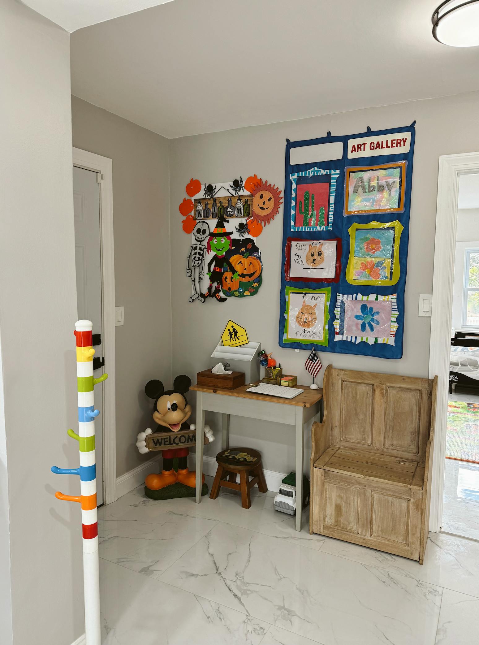 Children's art gallery display with Halloween decorations and a small desk