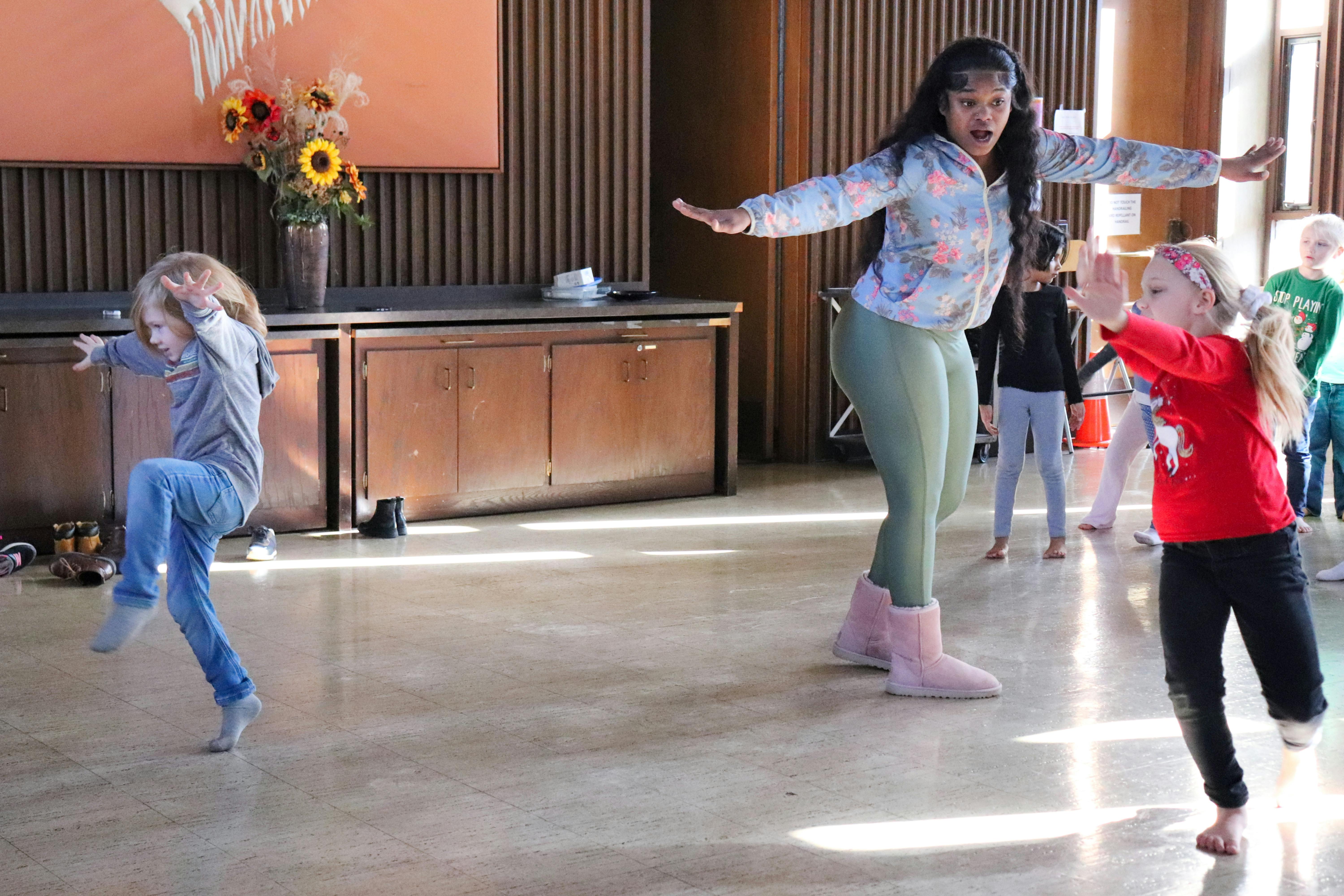 Three people dancing with arms outstretched