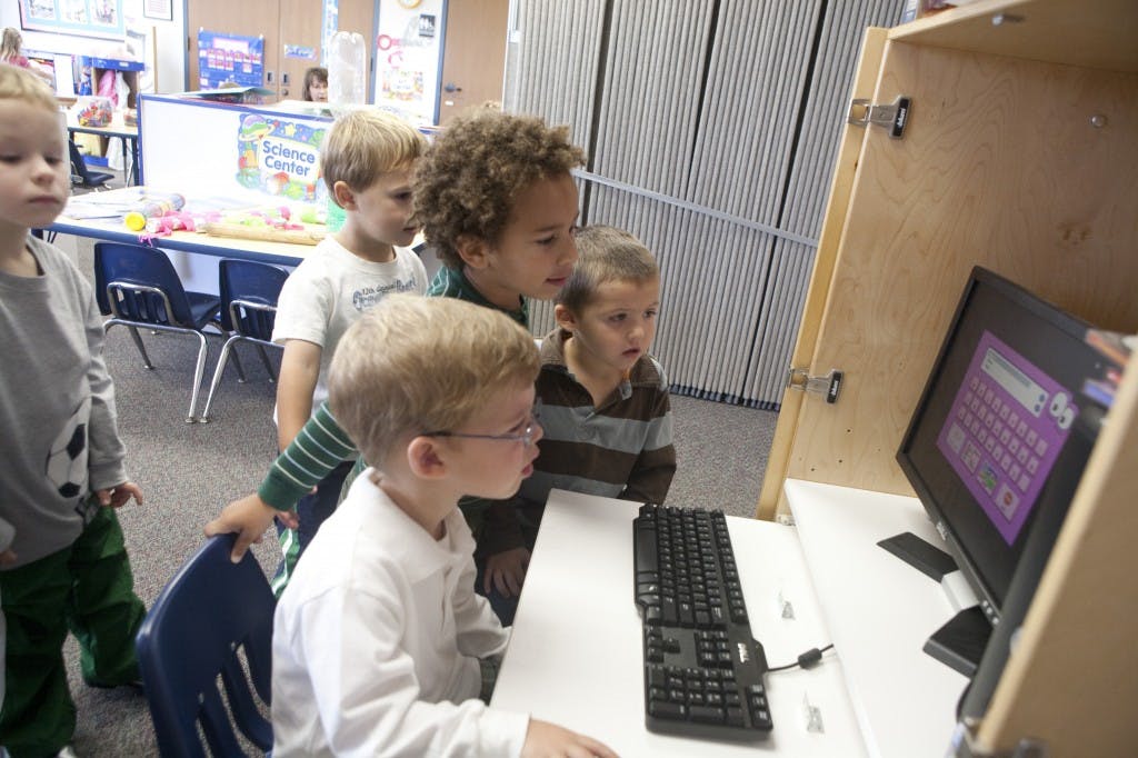 Four children looking at a computer screen