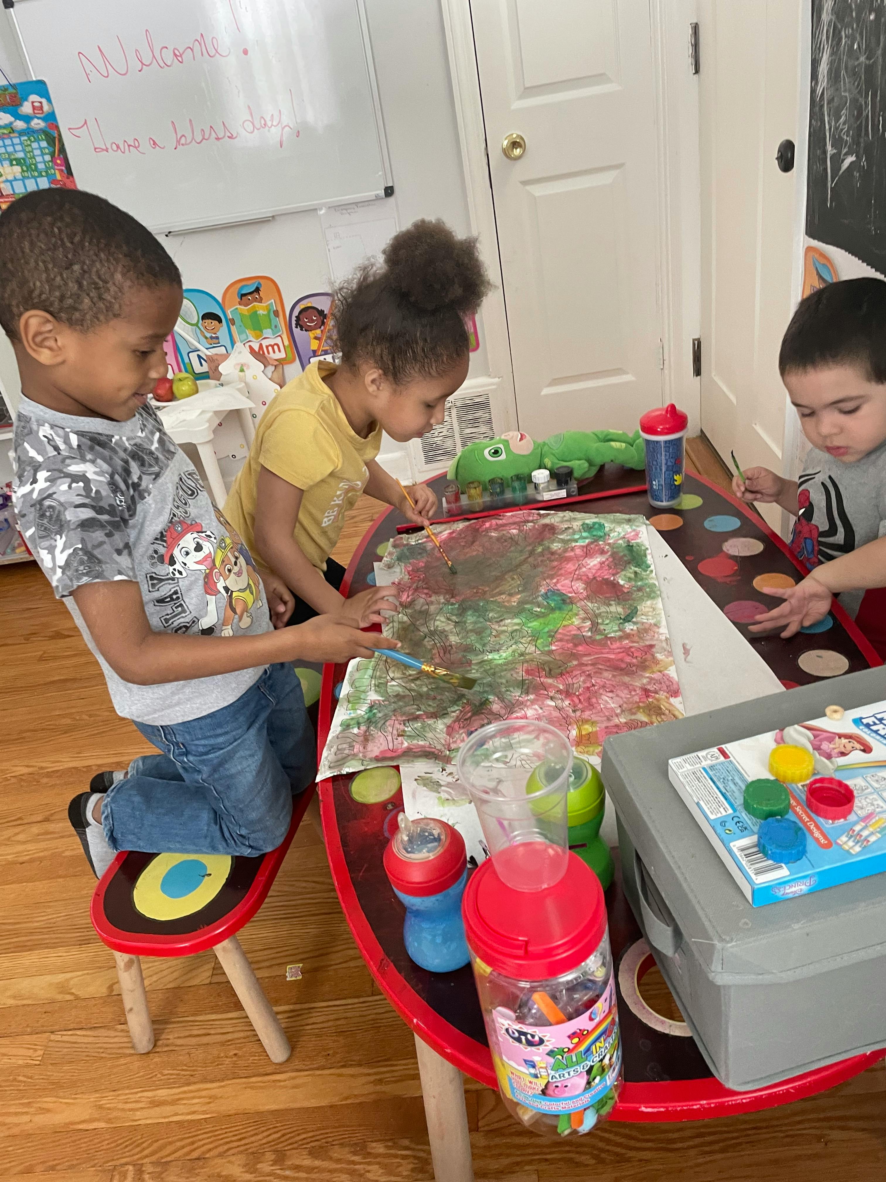 Three children painting at a table