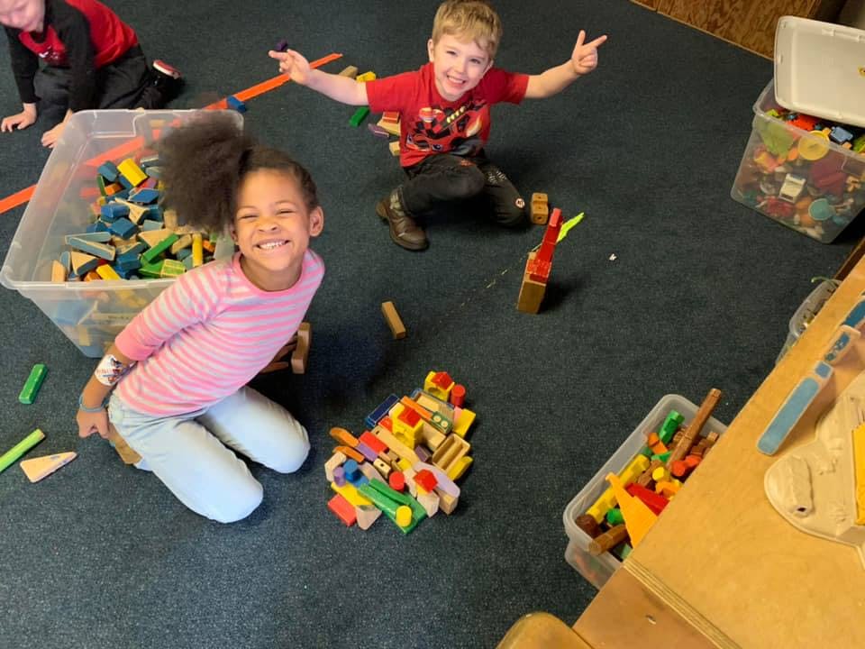 Two children playing with blocks on the floor