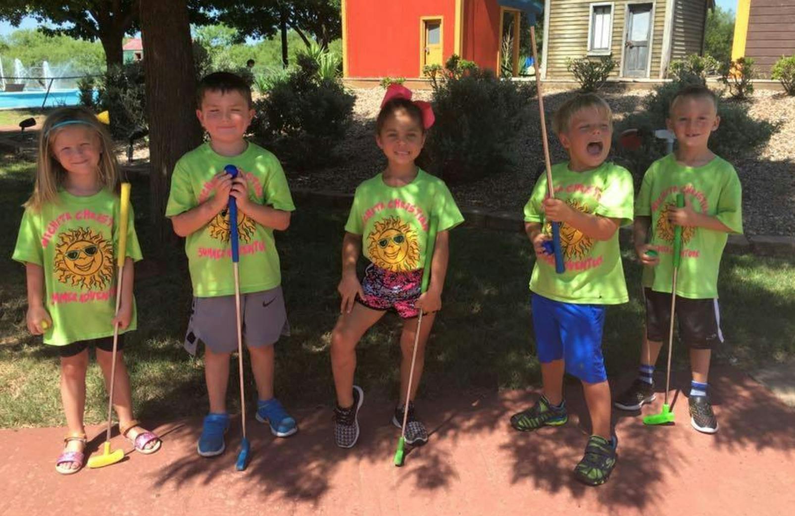Five children holding golf clubs