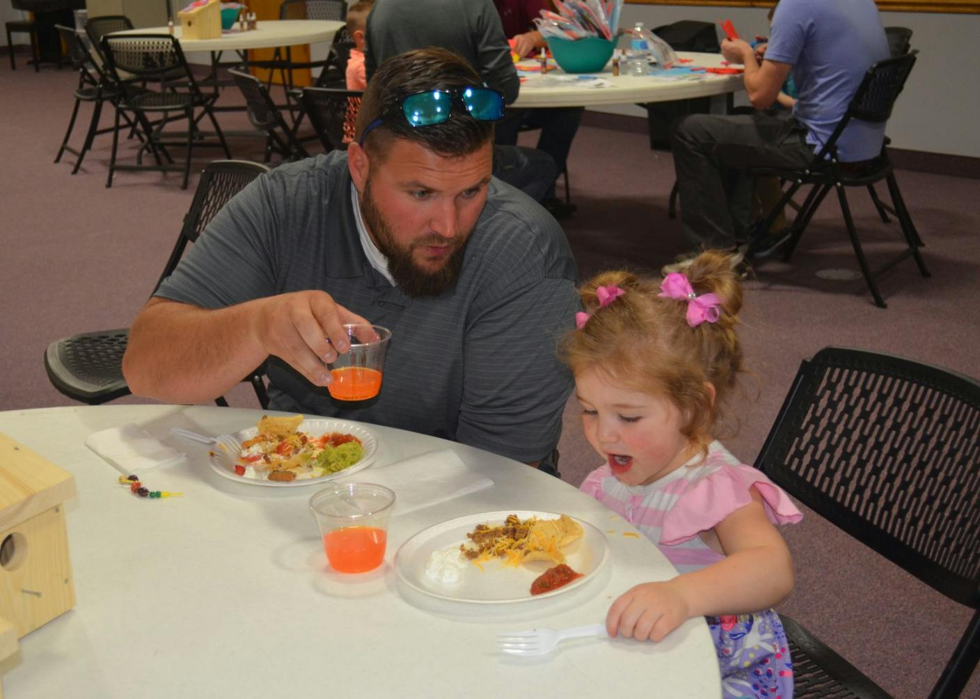Adult and child at a table with food and plates of food