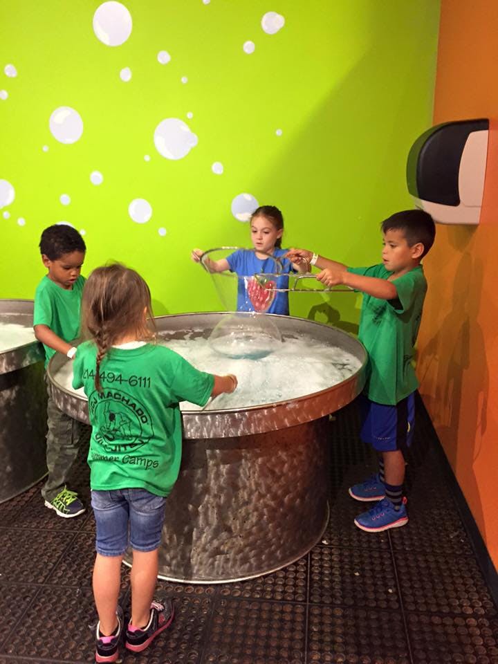 Children playing with bubbles at a bubble station
