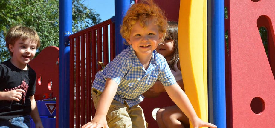 Children playing on a colorful playground structure