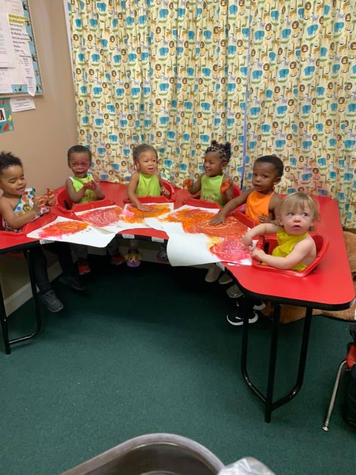 Children sitting at a table with art supplies