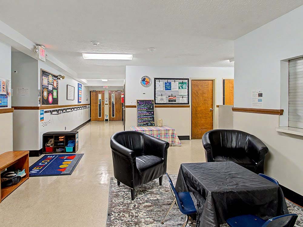 Hallway with bulletin boards, chairs, and tables