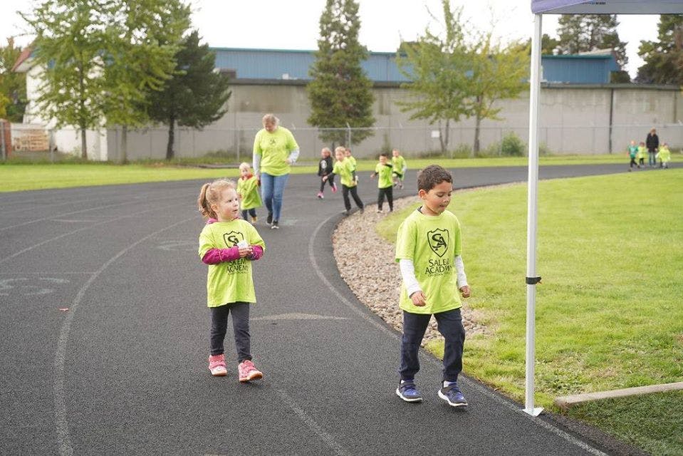 Children and adults walking on a track