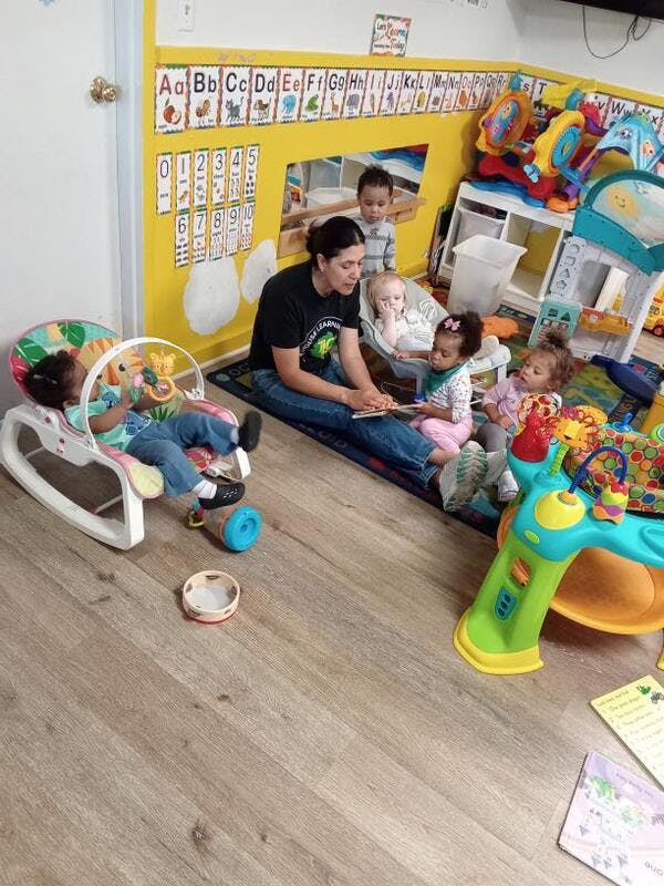 Person reading to multiple children in a classroom