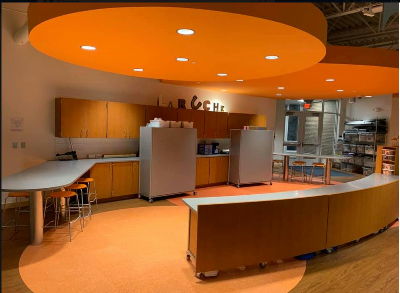 Kitchen area with orange ceiling and floor, wooden cabinets, and two refrigerators