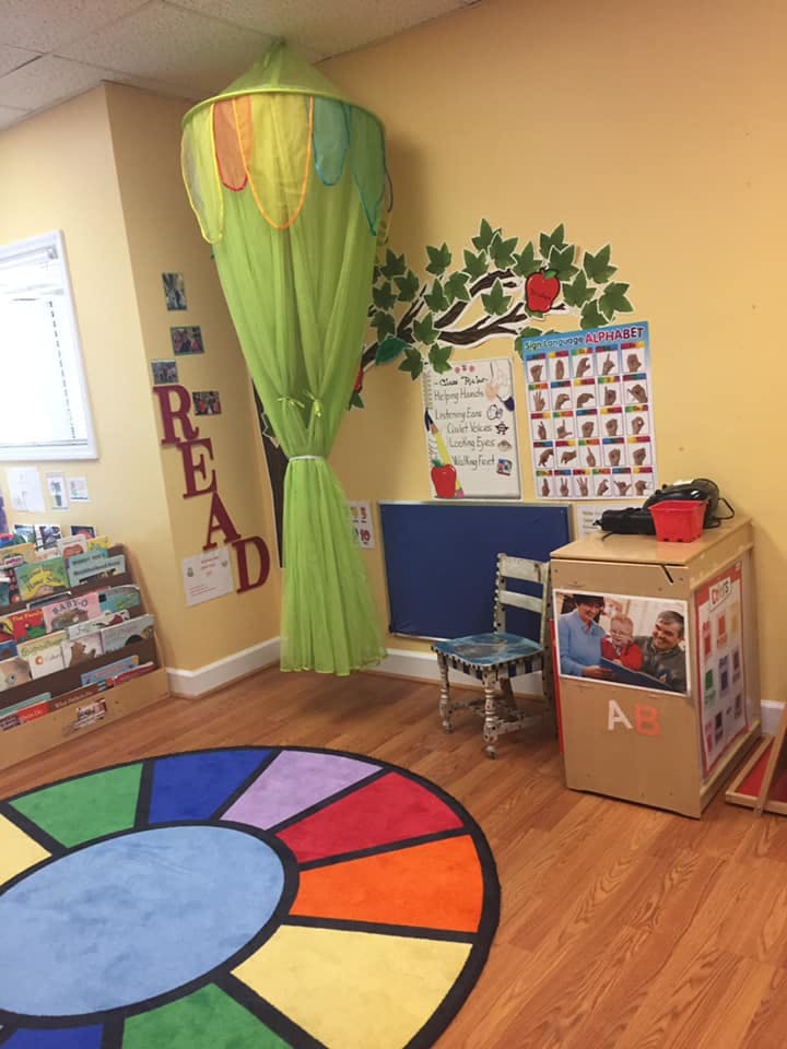 Children's reading nook with a colorful rug and book display