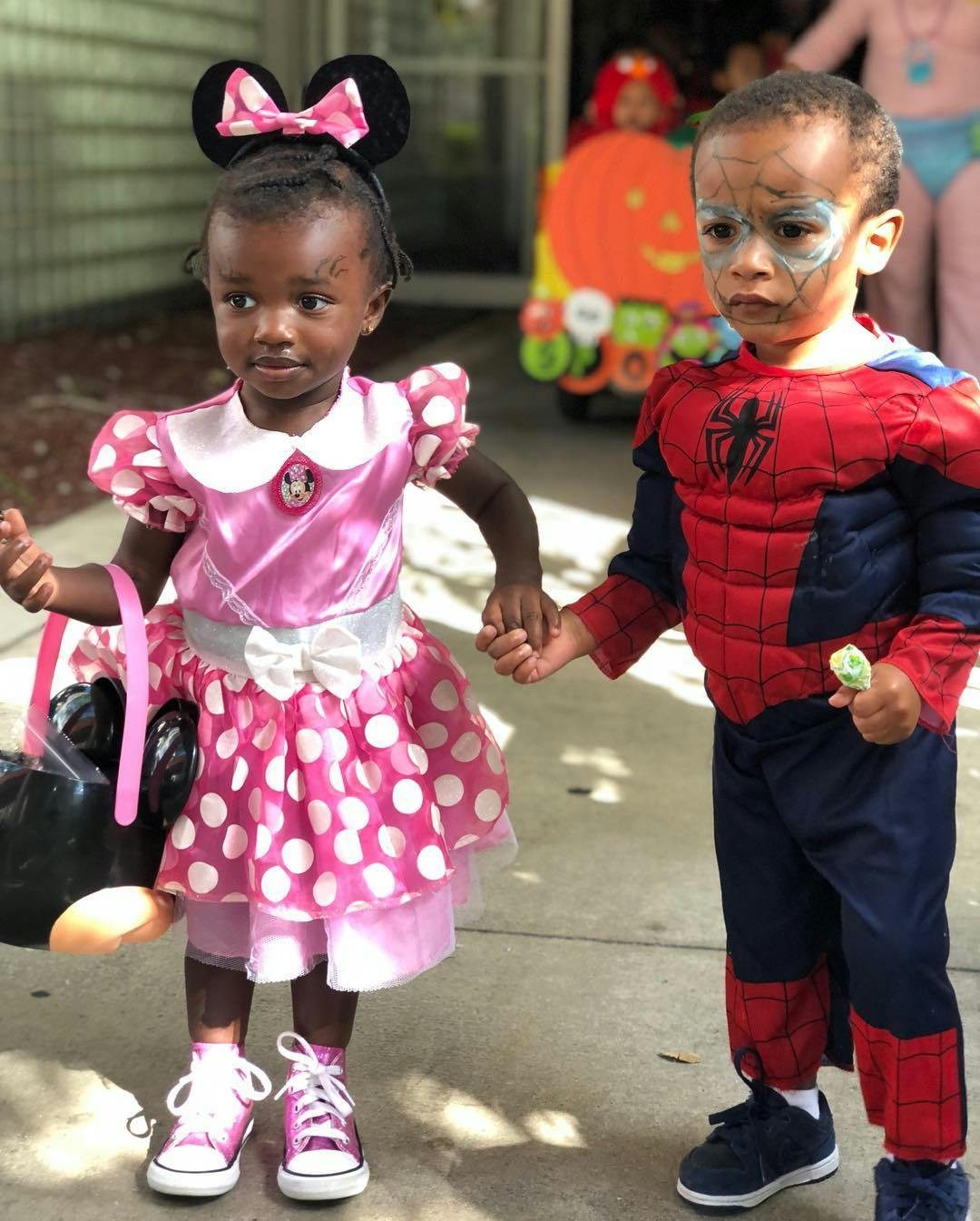 Two children in costumes holding hands