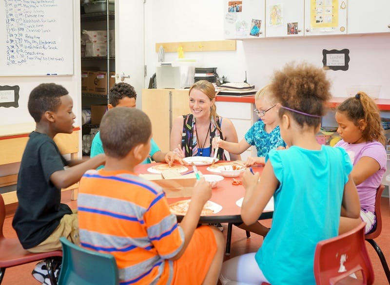 Adult and children sitting around a table in a classroom