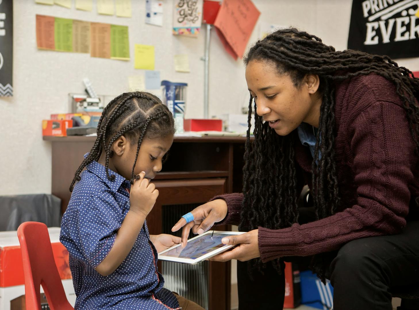 Person showing a child how to use a tablet