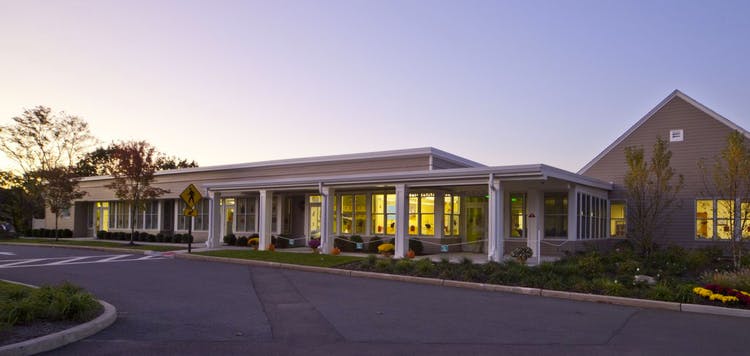 Exterior of a modern building with a long covered walkway and large windows