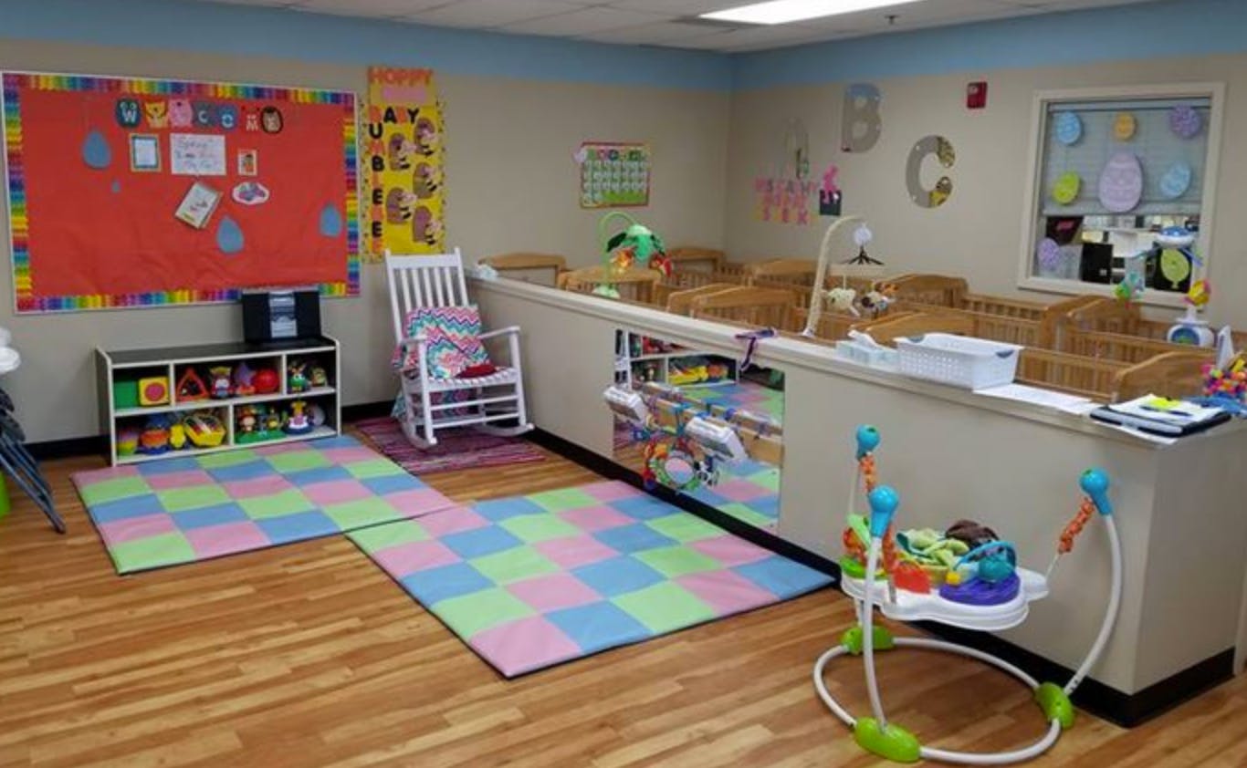 Playroom with colorful mats, cribs, and toys