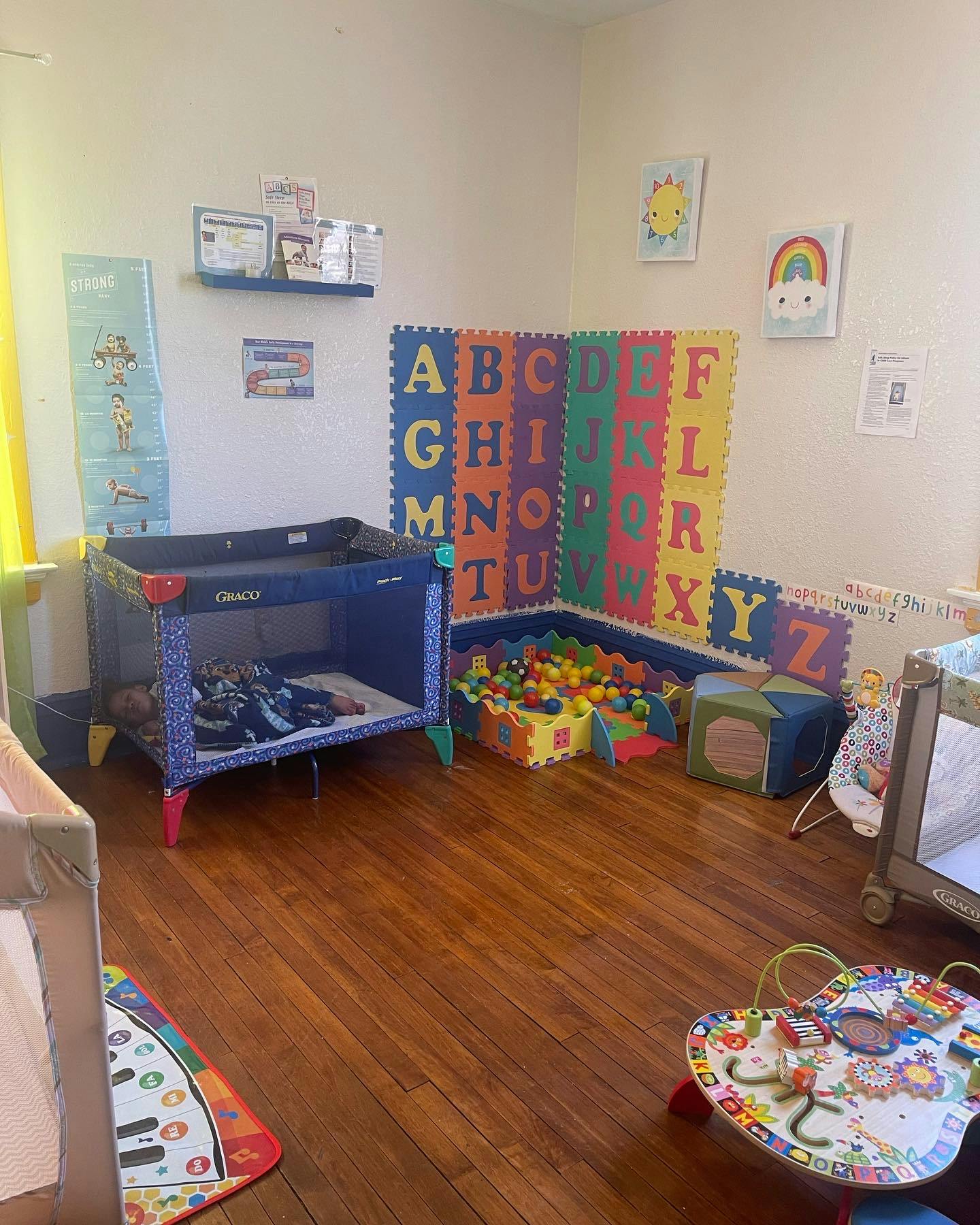 Playroom with a crib, ball pit, and alphabet mat