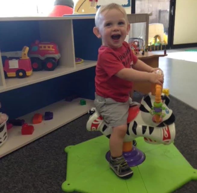 Child on a zebra-shaped rocking toy