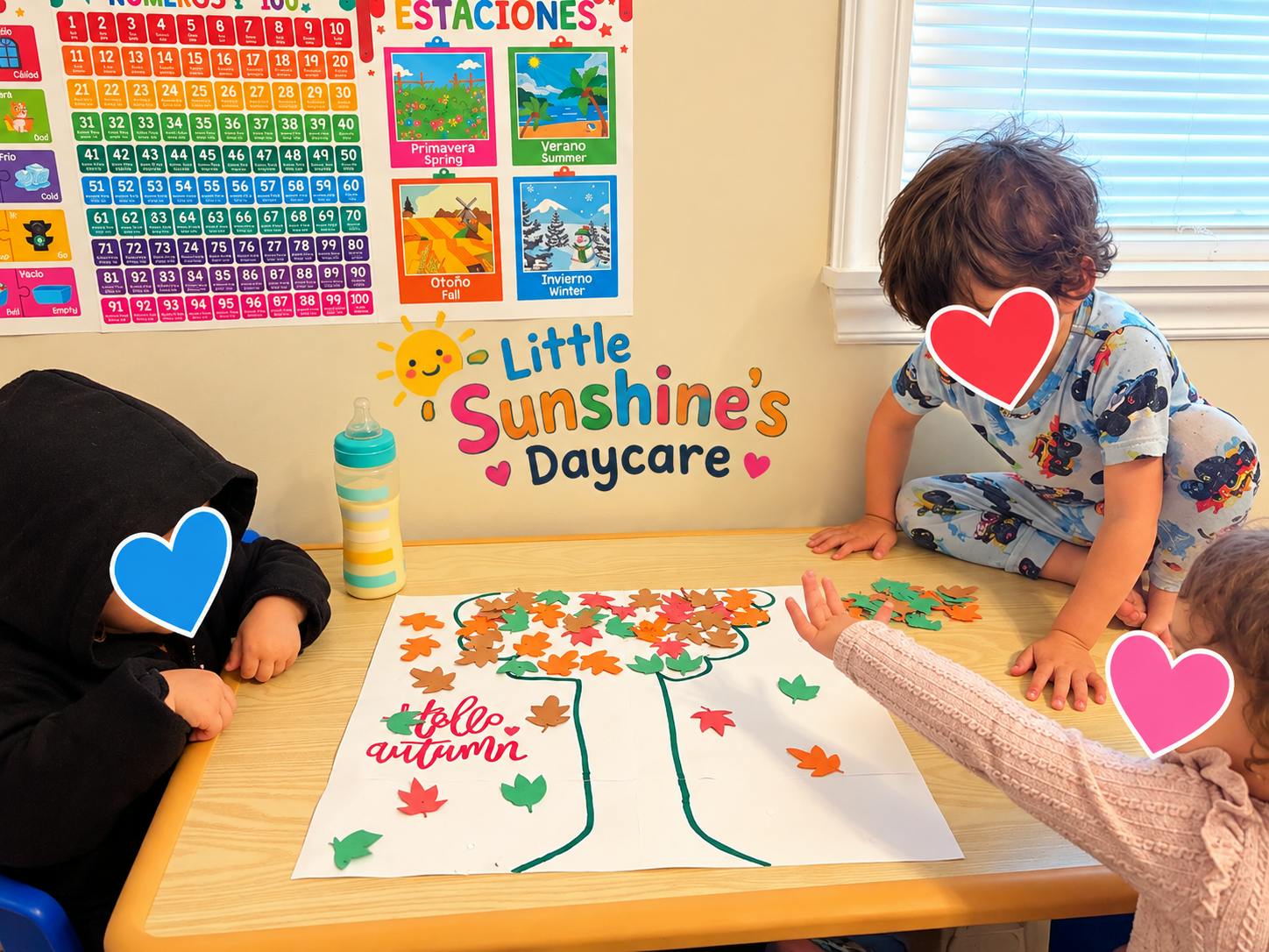 Three children crafting a paper tree with autumn leaves at a table
