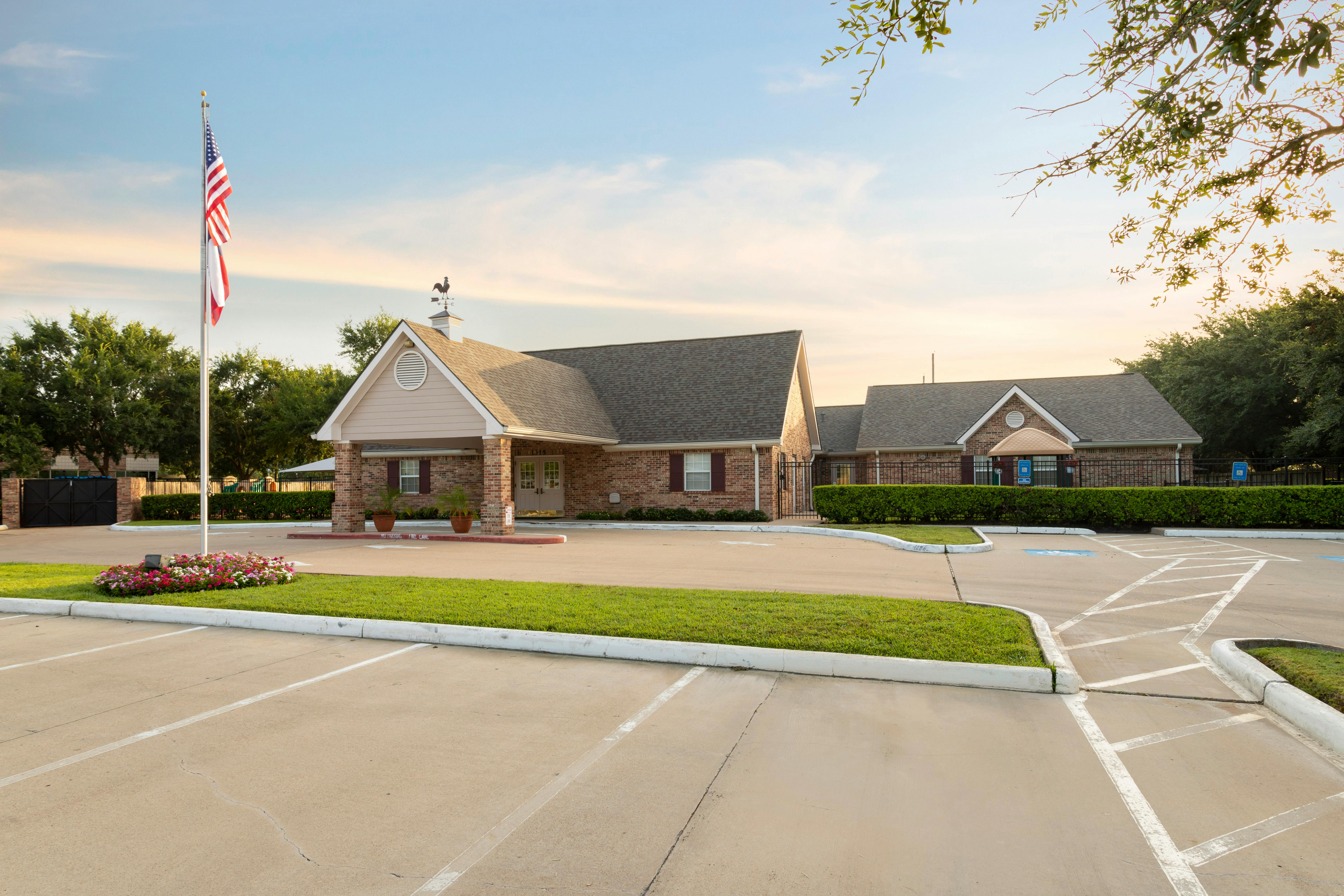 Brick building with a parking lot and American flag