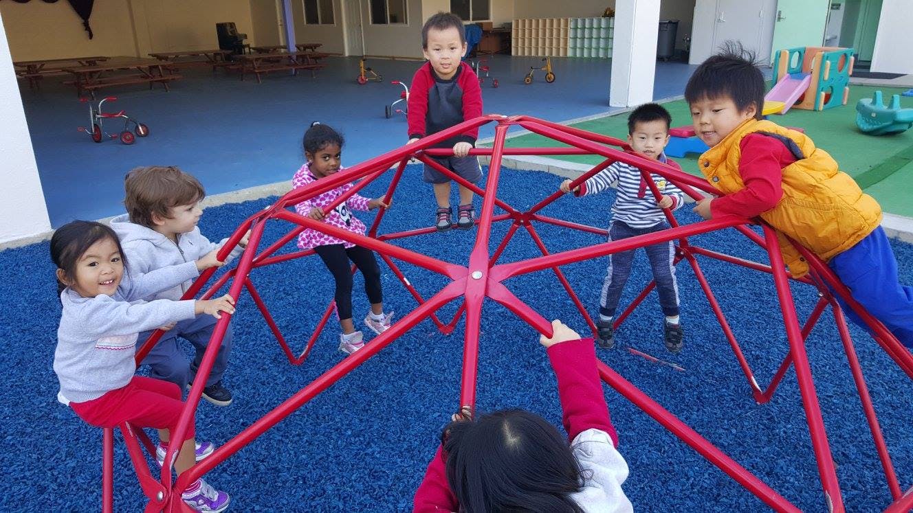 Children playing on a red climbing dome