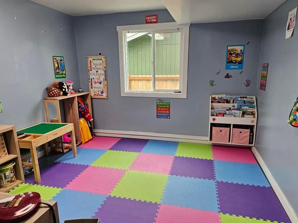 Playroom with colorful foam floor tiles, small table, and bookshelves