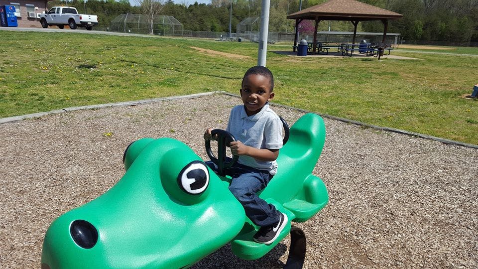 Child on a green spring rider at a playground
