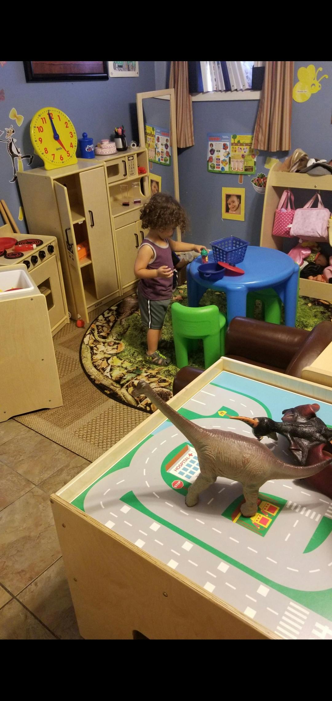 Child playing with toys at a small table in a playroom
