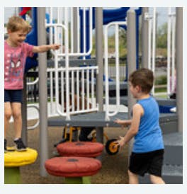 Two children playing on playground equipment