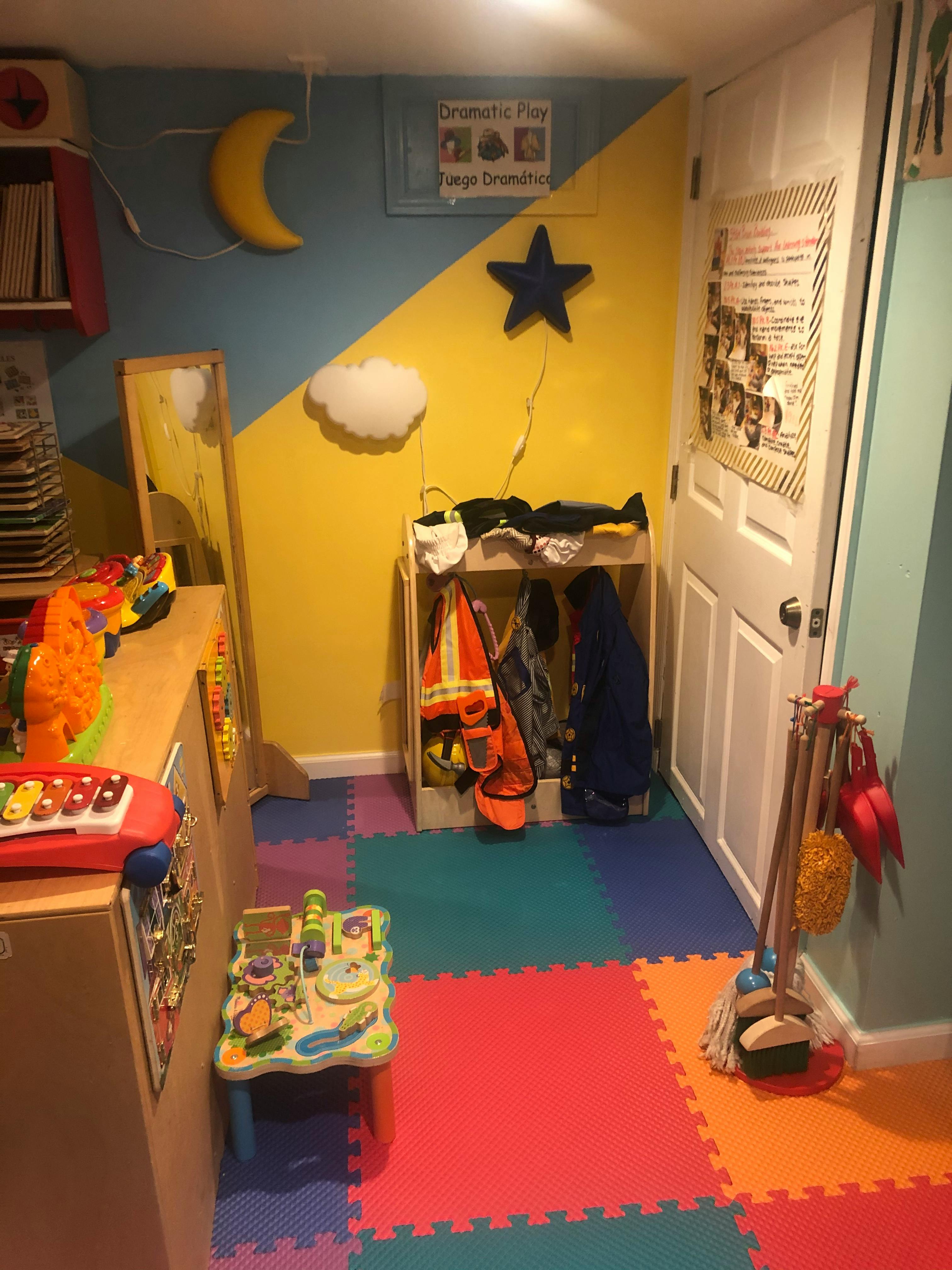 Playroom with colorful floor mats, toys, and wall decorations