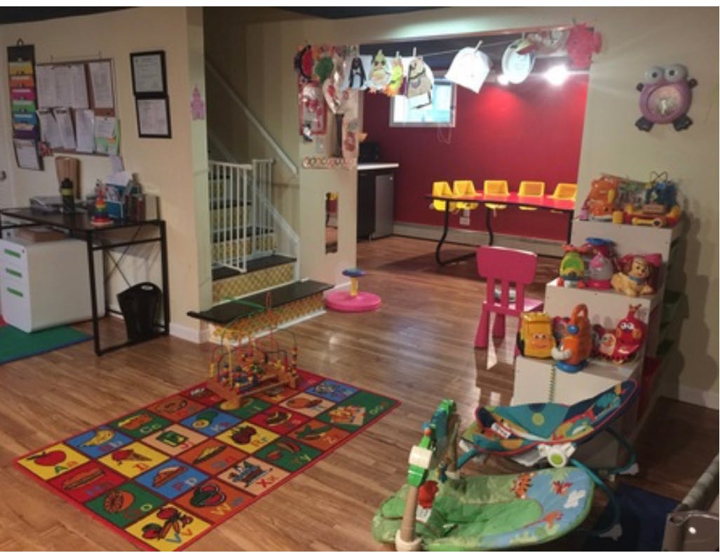 Playroom with colorful rug, toys, and small table with chairs