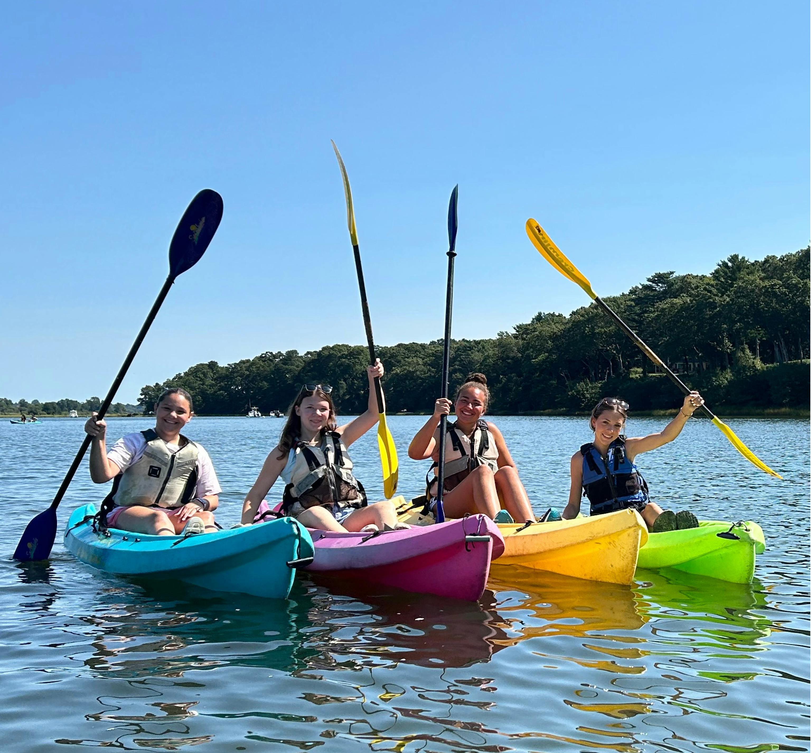 Four children in kayaks on the water