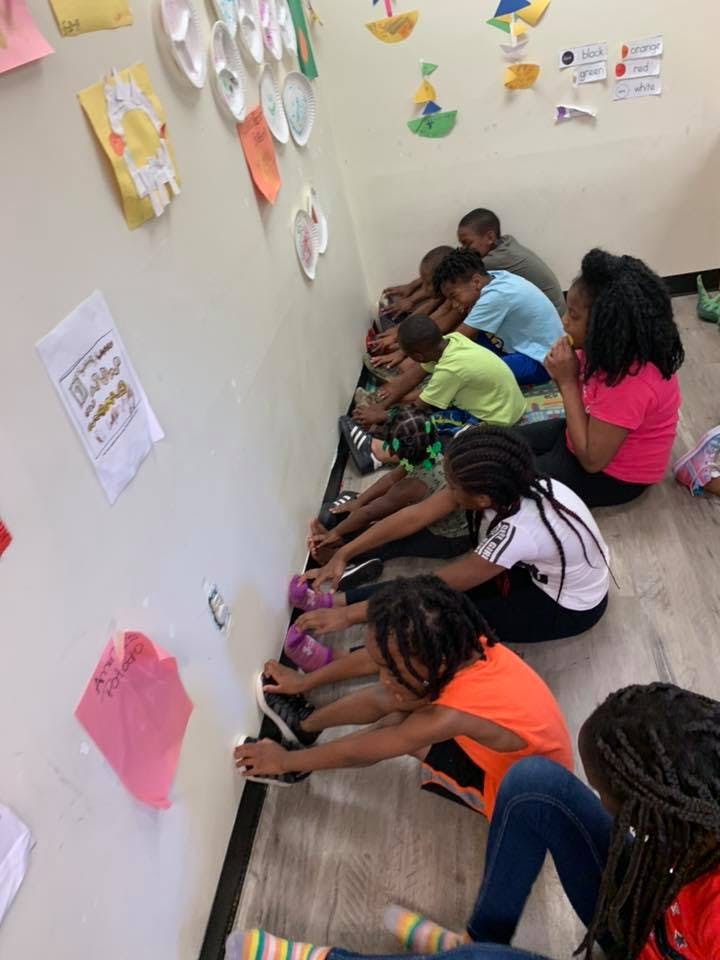 Children sitting on the floor stretching their legs