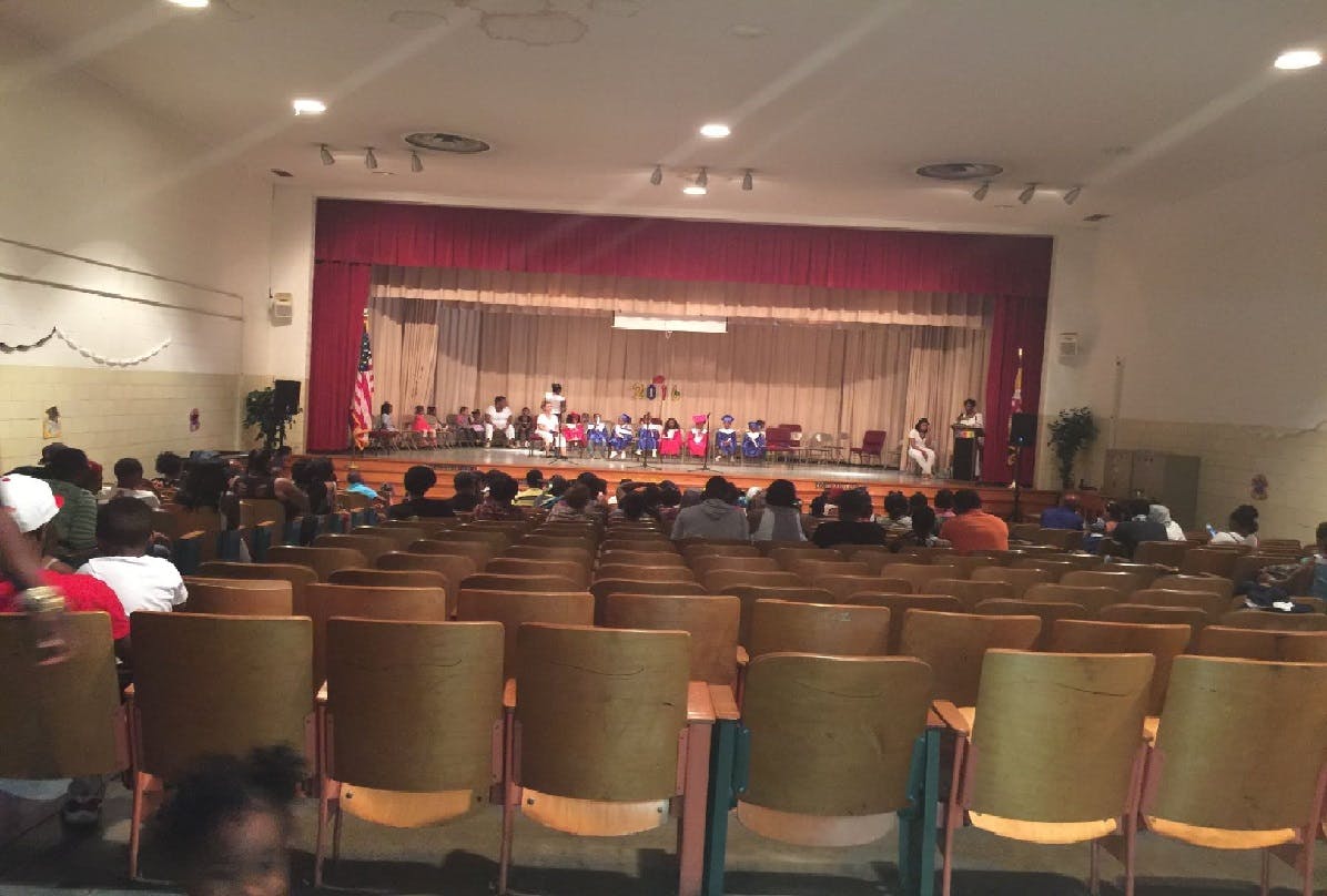 Auditorium with people seated and children on a stage