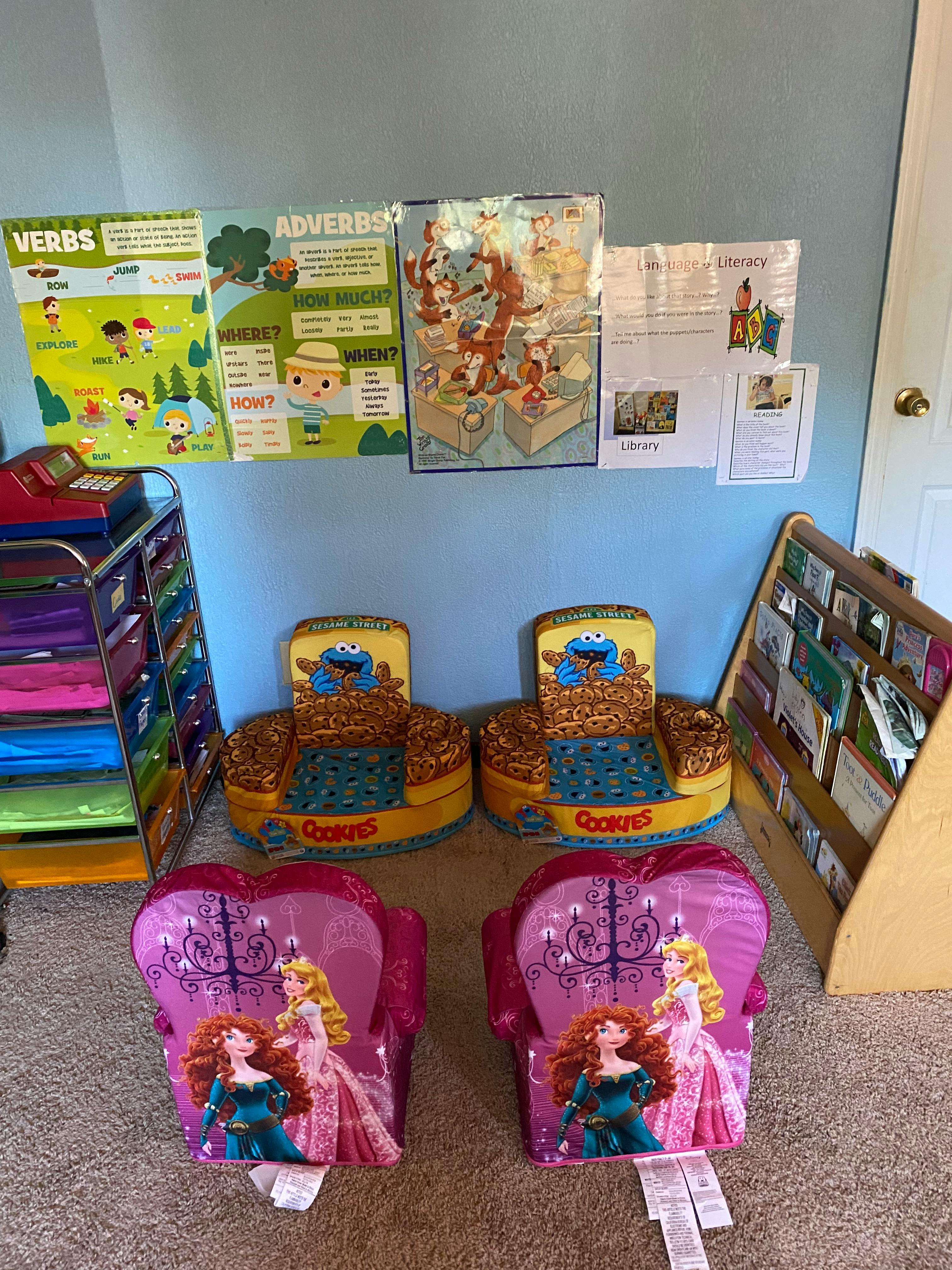 Four children's chairs in a room with educational posters and a book display