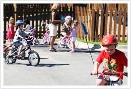 Children on bicycles with adults nearby