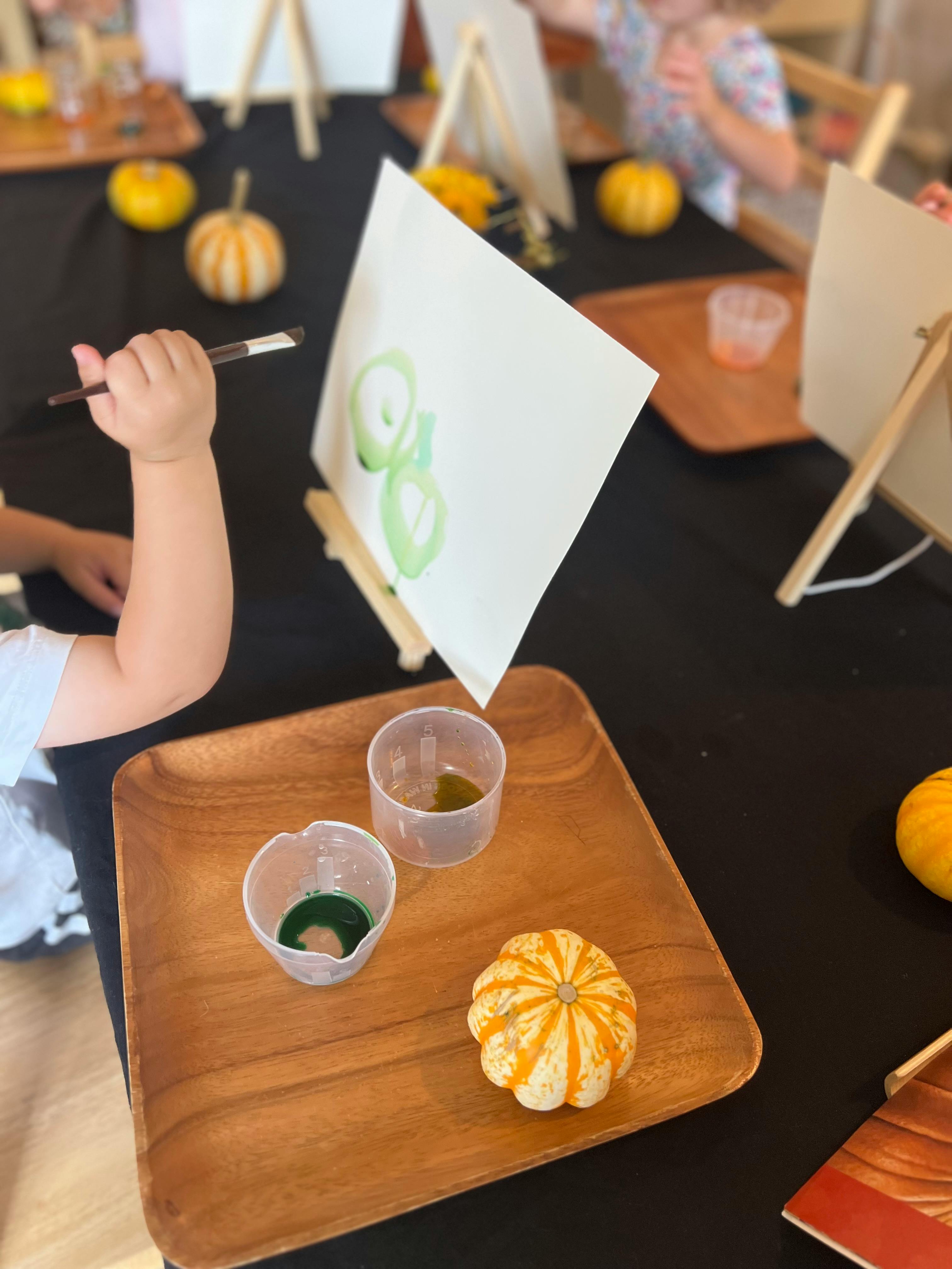 Child painting on an easel with a paintbrush