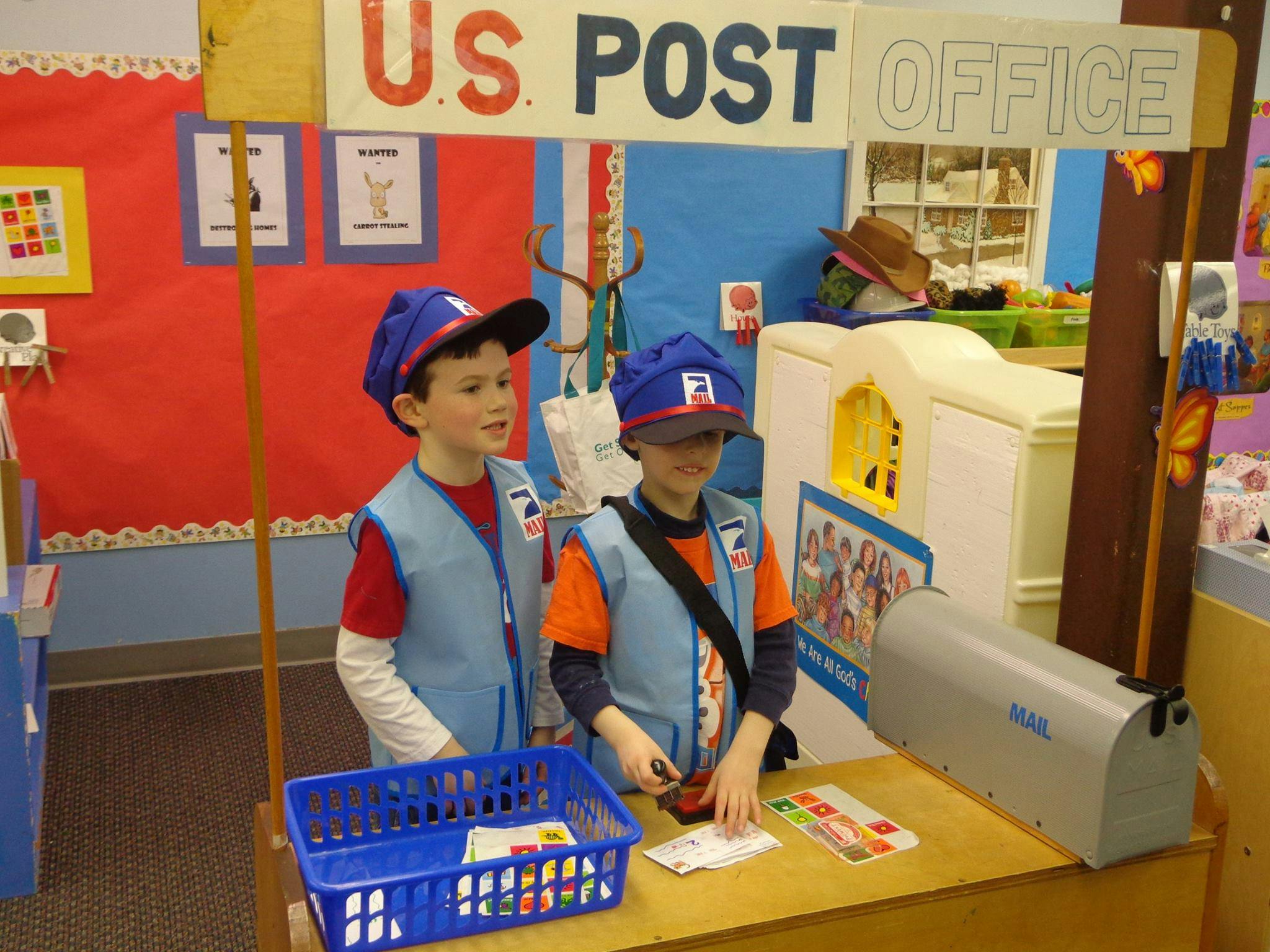 Two children in postal worker costumes at a play post office