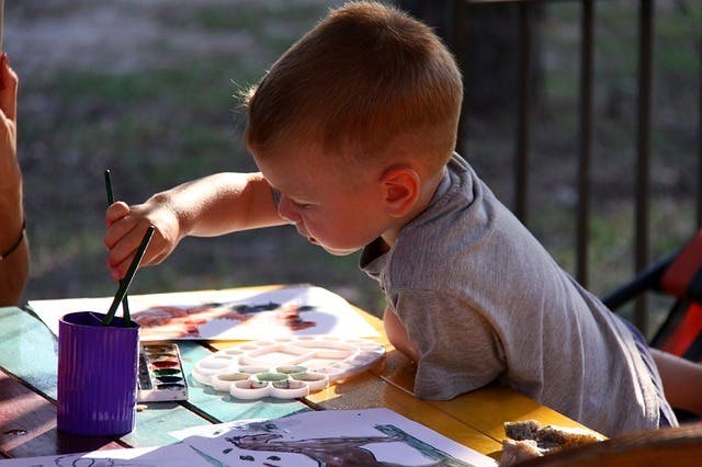 Child painting with watercolors atabletop watercolor set