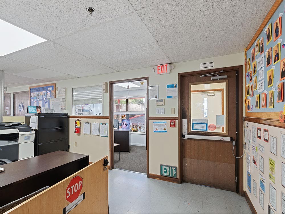 Office interior with a reception desk, two doorways, and bulletin boards