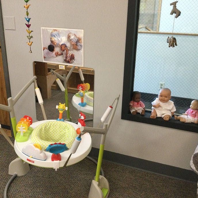 baby jumper and three baby dolls in a classroom